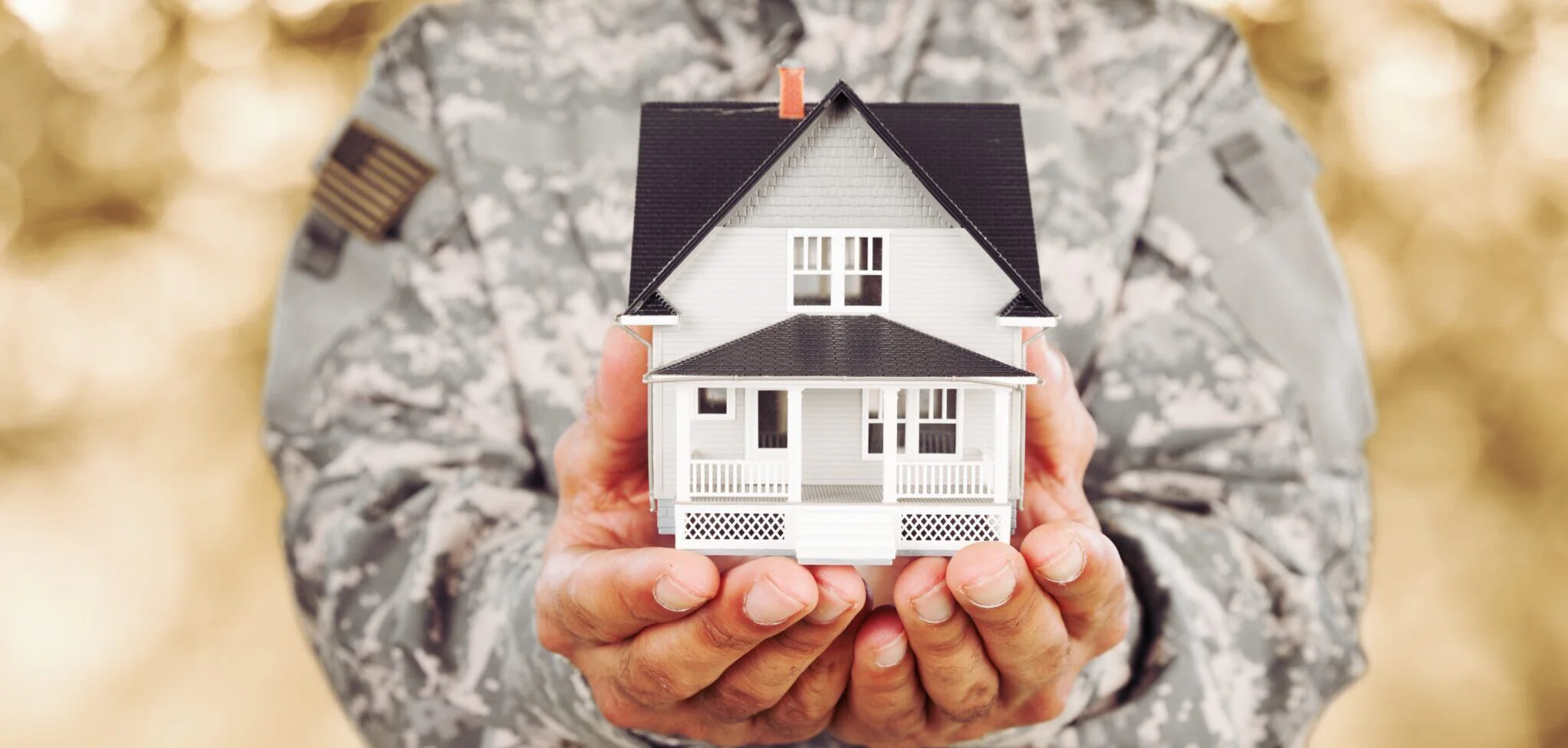 American soldier holding a model of house