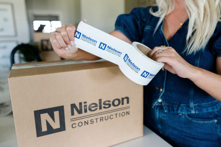 Woman with Nielson tape sealing moving box
